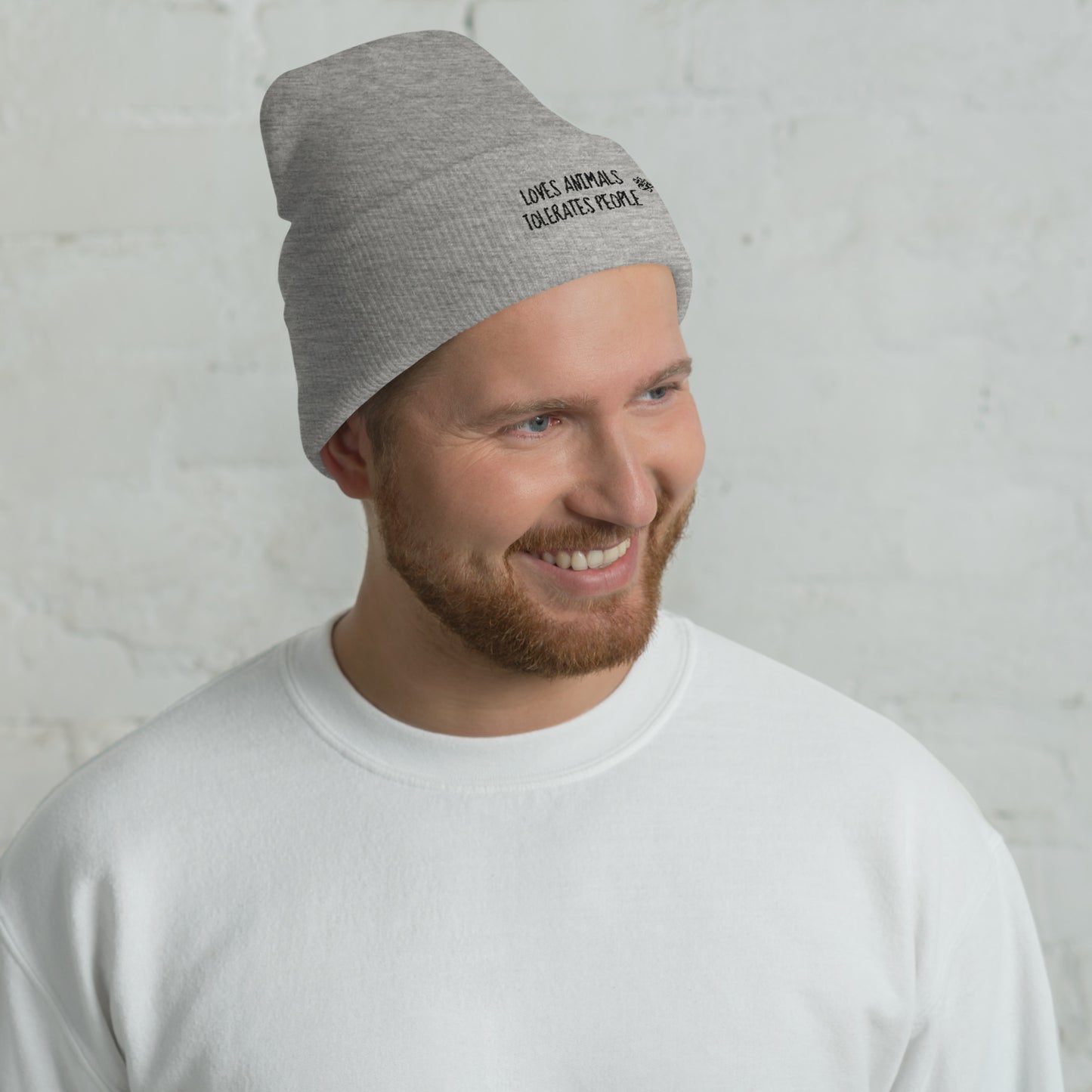 Guy with green cuffed beanie with black loves animals tolerates people embroidery