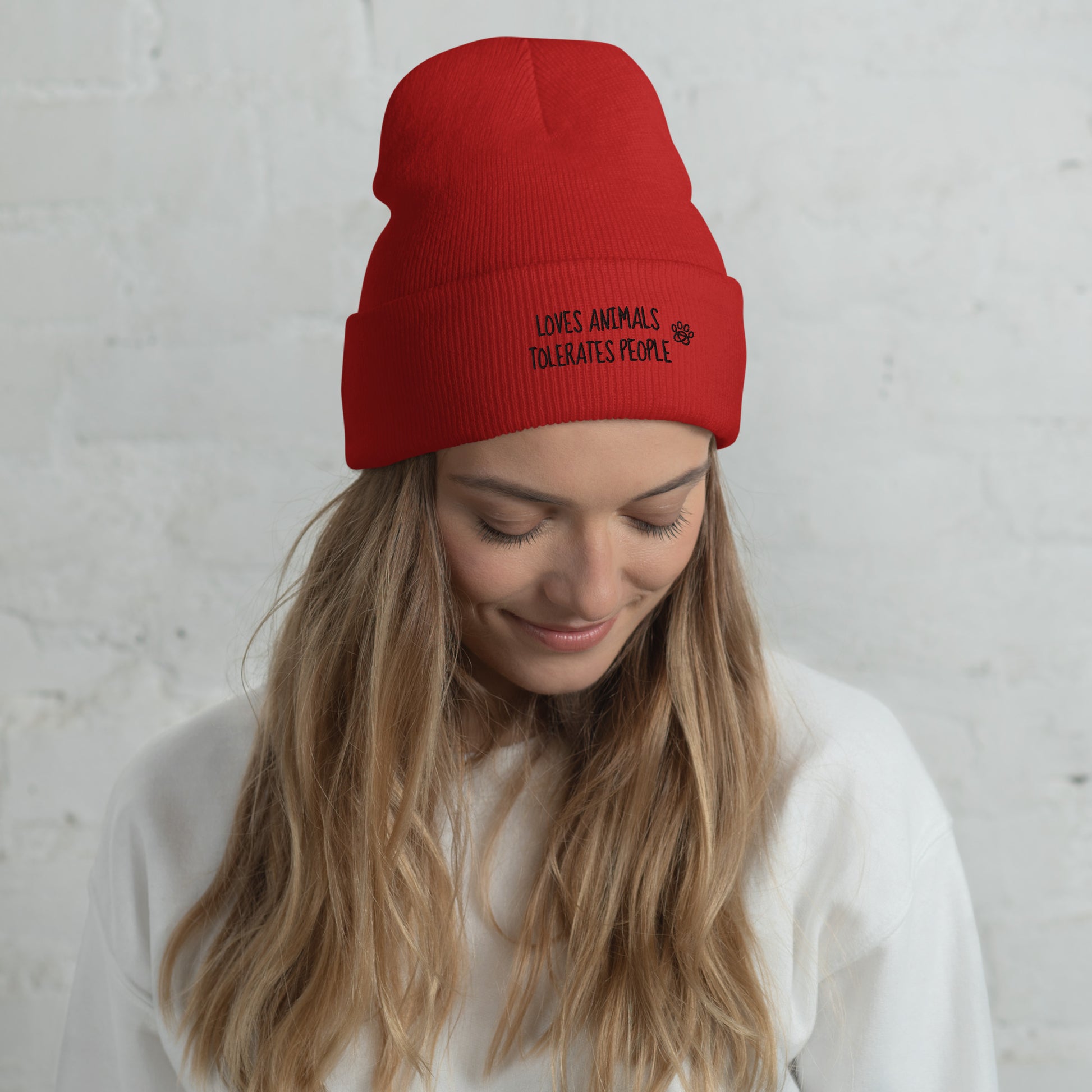 Girl with red cuffed beanie with black loves animals tolerates people embroidery