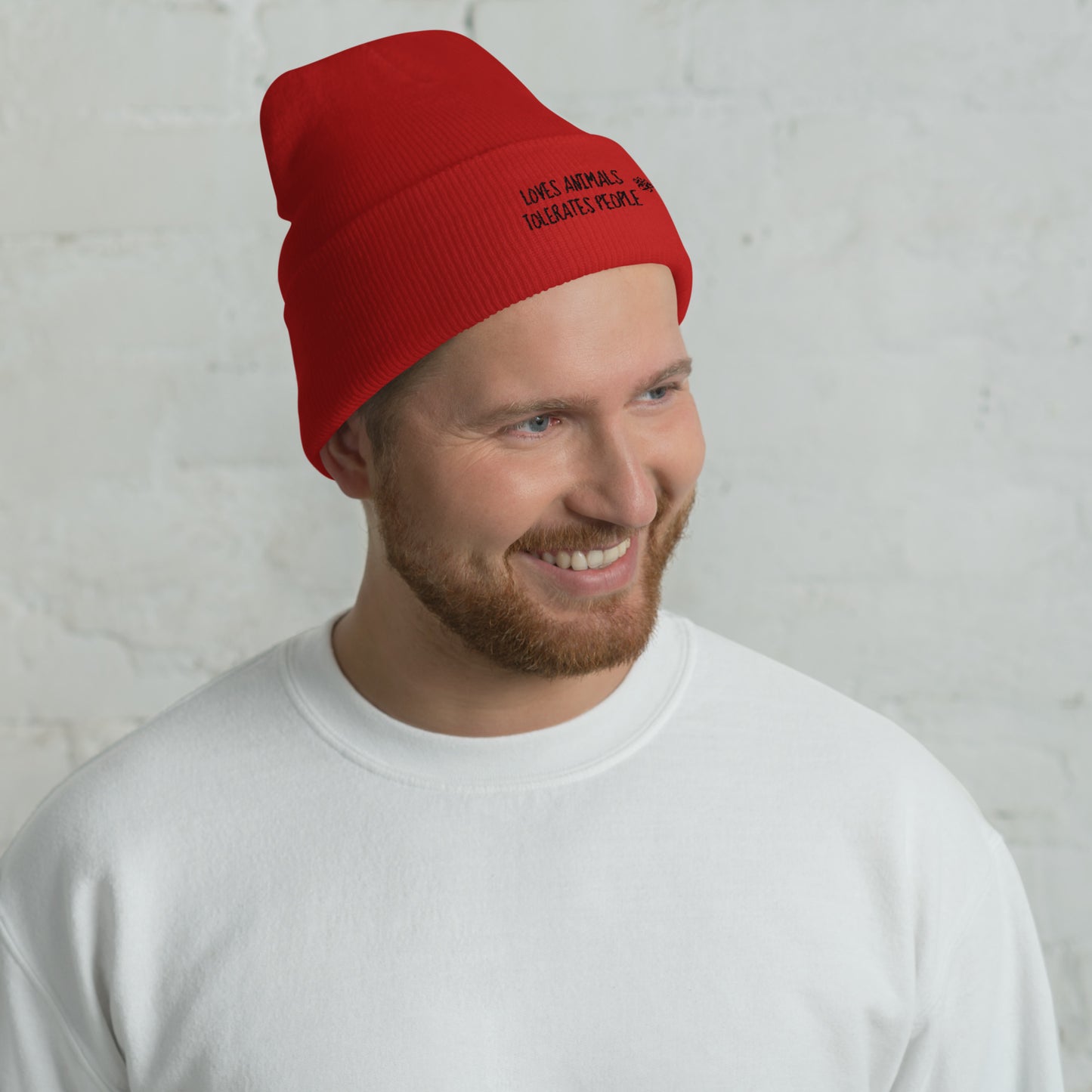 Guy with red cuffed beanie with black loves animals tolerates people embroidery