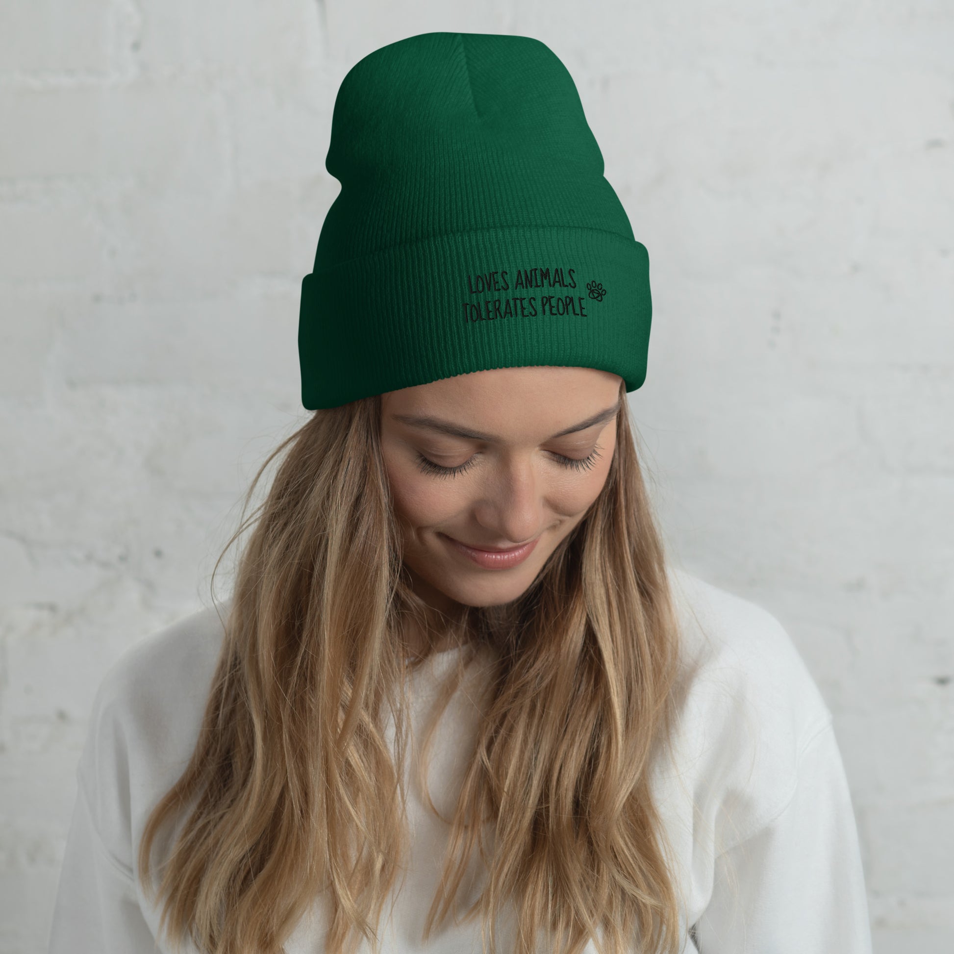 Girl with green cuffed beanie with black loves animals tolerates people embroidery