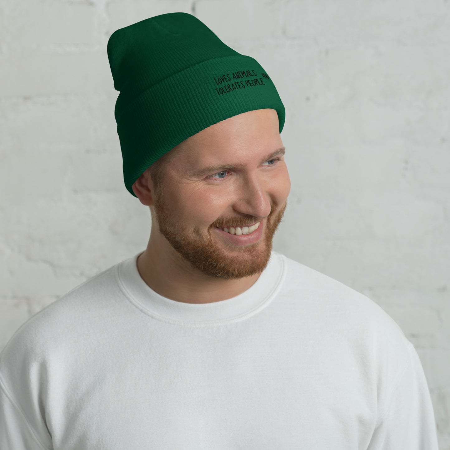 Guy with green cuffed beanie with black loves animals tolerates people embroidery