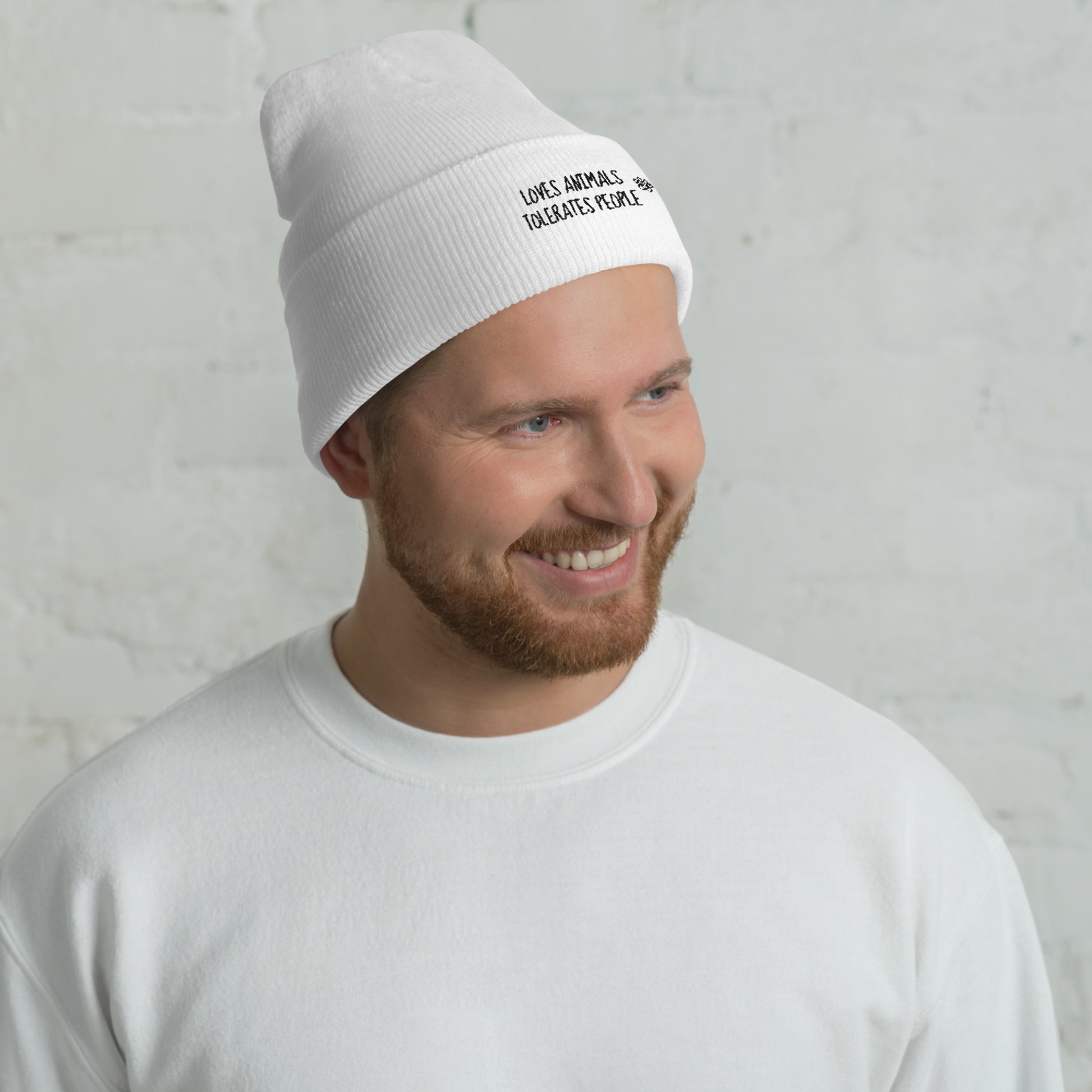 Guy with white cuffed beanie with black loves animals tolerates people embroidery